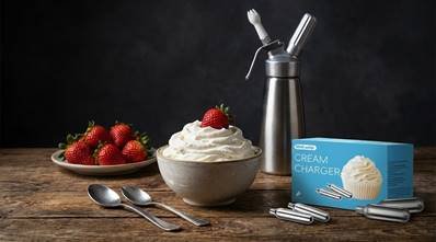 Professional whipped cream dispenser with a bowl of fresh cream and strawberries.